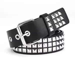Detailed view of black punk belt featuring three rows of silver pyramid studs and a buckle.
