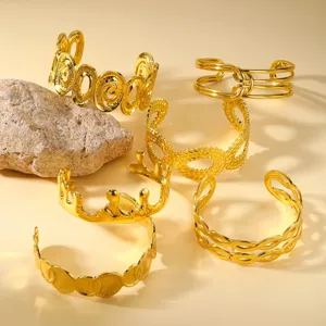 Detailansicht verschiedener 18K vergoldeter Titanstahl-Manschettenarmbänder mit Designs