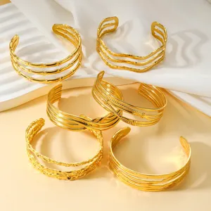 Nahaufnahme von 18K vergoldeten Titanstahl-Manschettenarmbändern mit verschiedenen Linientexturen