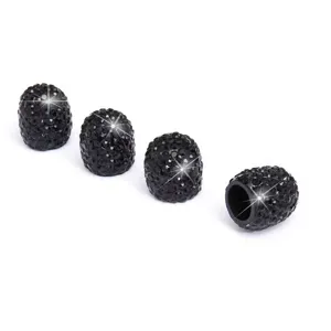 Close-up detail of sparkling black rhinestone car tire valve caps, universal decorative dust covers.