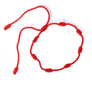 Vista dettagliata del bracciale a corda rossa fatto a mano con 7 nodi peruviani