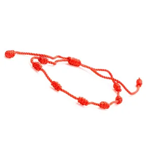 Vista dettagliata del bracciale a corda rossa fatto a mano con sette nodi peruviani.