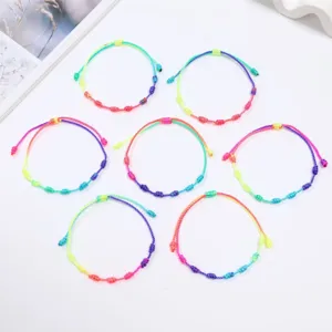 Vista dettagliata dei braccialetti intrecciati a mano con nodi peruviani arcobaleno