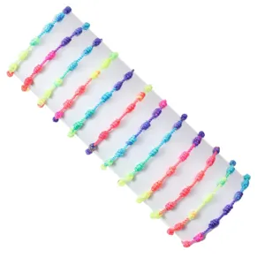 Braccialetti colorati intrecciati a mano con sette nodi peruviani su espositore bianco