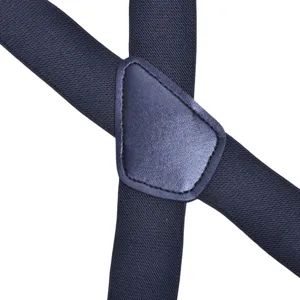 Detailed close-up view of dark blue elastic suspenders with leather back junction patch.