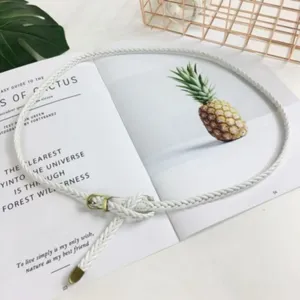 Primo piano dettagliato di una cintura sottile intrecciata bianca con fibbia su rivista.