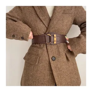 Dettaglio cintura elastica larga marrone con fibbia dorata su un blazer elegante