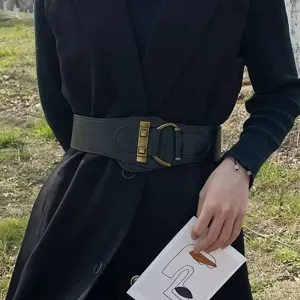 Cintura larga elastica nera alla moda con fibbia dorata vintage su un blazer nero