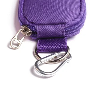 Detailed view of purple fabric storage pouch with zipper, strap, and metal carabiner hook.