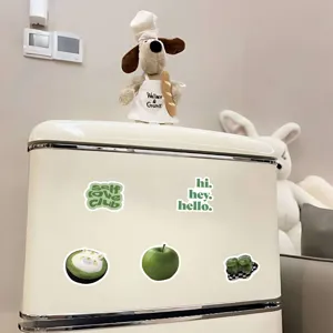 Vue détaillée d'autocollants décoratifs esthétiques verts sur un petit réfrigérateur.