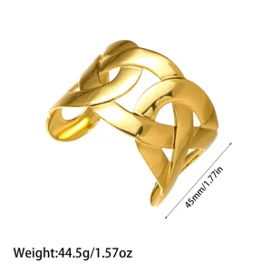 Vista detallada de un brazalete ancho de acero de titanio chapado en oro trenzado.