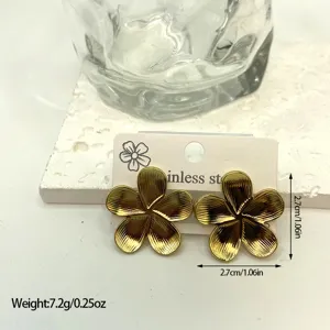 Detail view of gold flower earrings in stainless steel with a striped textured finish