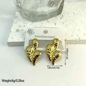 Close-up of golden hammered stainless steel geometric earrings showing size and weight