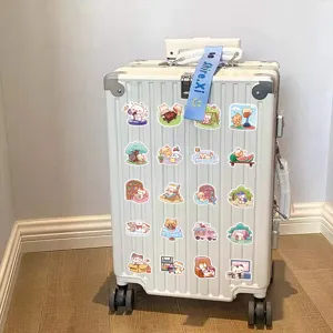 Colección de varias pegatinas de gatos de dibujos animados en una maleta blanca, detalle.