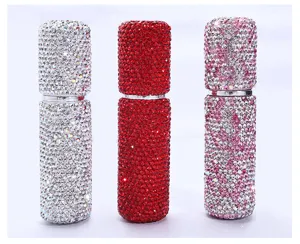 Detalle de tres frascos de perfume con pedrería en plata, rojo y rosa