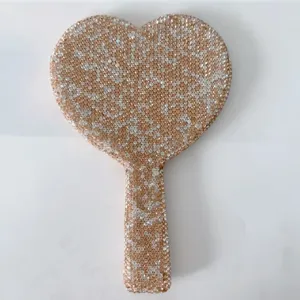 Close-up detail of the sparkling rhinestone heart-shaped handheld makeup mirror handle.