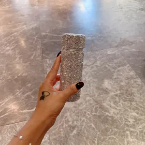 Tragbare Mini-Thermosflasche aus Edelstahl mit glänzenden Strasssteinen in der Hand