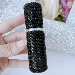Primer plano de la elegante superficie con cristales negros de un frasco atomizador de 5 ml