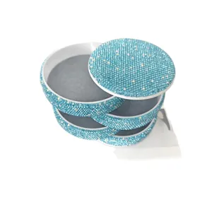 Funkelnde blaue Strass-Mehrschicht-Drehbox für Kosmetik und Schmuck auf dem Schreibtisch