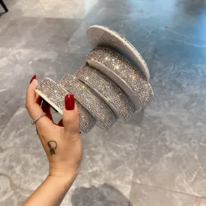 Gros plan sur les strass scintillants de la boîte à bijoux rotative aux détails élégants.