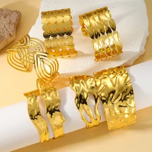 Vista detallada de brazaletes de acero de titanio chapado en oro 18K con texturas variadas