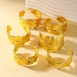 Detalle macro de varios brazaletes de hojas en acero inoxidable chapado en oro 18K