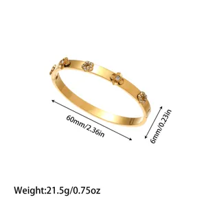Elegant gold-plated stainless steel bangle with crystal flower charms and size info.