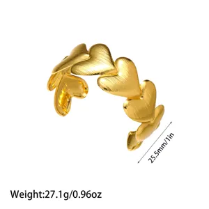 Detalle de brazalete de corazón de acero inoxidable bañado en oro de 18K con textura cepillada