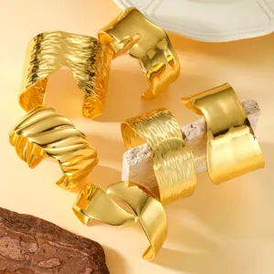 Primer plano de varios brazaletes de acero inoxidable chapados en oro de 18K