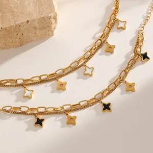 Nahaufnahme des goldenen Doppelarmbands mit schwarzen und weißen Sternanhängern