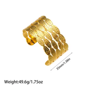 Detalle de un brazalete ancho de acero inoxidable chapado en oro de 18 quilates martillado