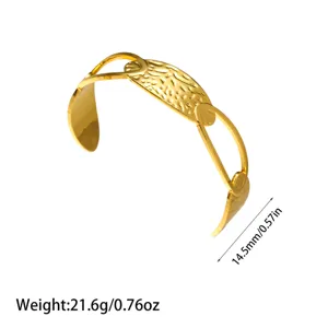 Detalle de un brazalete rígido de acero de titanio dorado martillado con medidas
