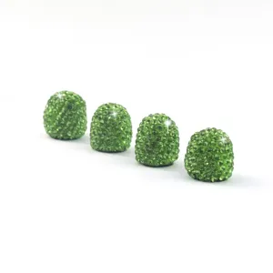 Close-up of green rhinestone car tire valve caps, sparkling crystal design for universal auto.