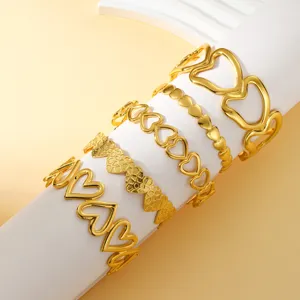 Detalle de varios brazaletes de acero inoxidable chapados en oro de 18K con forma de corazón