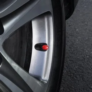 Sparkling red rhinestone car tire valve cap detail shot, universal fit for wheel rims.