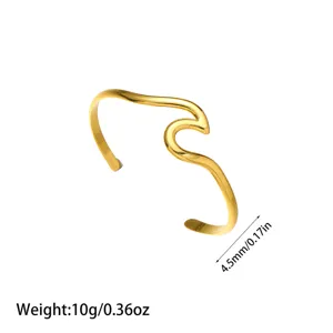 Vista detallada del brazalete de ondas de acero de titanio chapado en oro de 18K