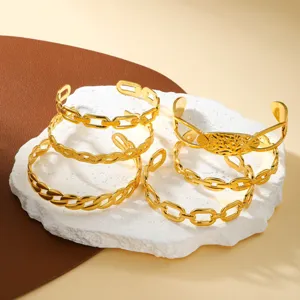 Conjunto de varios brazaletes de cadena de acero inoxidable dorado sobre base de piedra