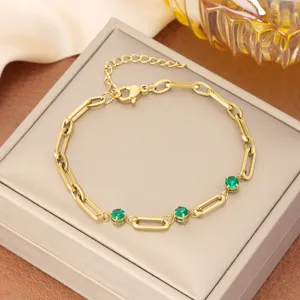 Vista detallada de una pulsera de eslabones de acero inoxidable dorado con circones verdes