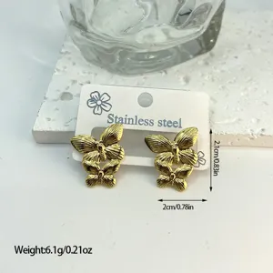 Detail view of gold-toned stainless steel butterfly earrings with striped texture