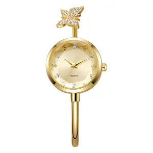 Detailansicht einer eleganten goldenen Schmetterlings-Armreif-Uhr mit klaren Strasssteinen