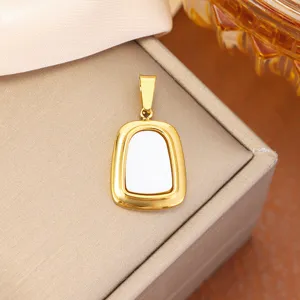 Macro view of elegant gold-toned stainless steel arch pendant with white inlay detail