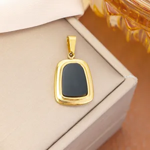 Close-up detail of a gold-plated stainless steel pendant with a black shield-shaped inlay