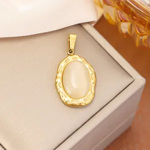 Macro detail of gold stainless steel pendant with hammered edge and cat's eye stone