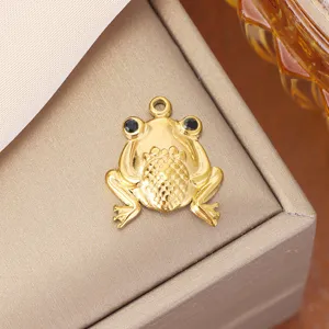 Detailed close-up of a gold-plated titanium steel frog pendant with black crystal eyes
