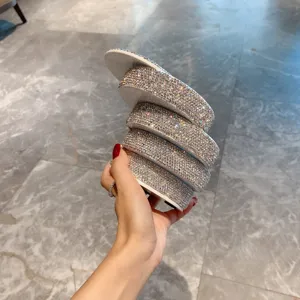 Vue détaillée d'une boîte à bijoux rotative étincelante en strass pour bagues et petits accessoires.