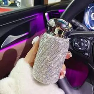 Nahaufnahme einer luxuriösen, mit Strass besetzten Sprühflasche im modernen Autoinnenraum