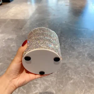 Gros plan détaillé de la surface scintillante en strass de la boîte à bijoux pivotante.