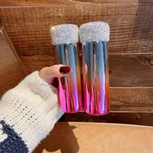 Nahaufnahme von tragbaren, mit Strass besetzten Sprühflaschen mit Metallverlauf.