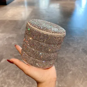Gros plan détaillé d'une boîte à bijoux rotative à strass multicouche, rangement scintillant.