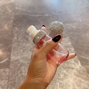 Detailansicht einer luxuriösen, mit Strass besetzten leeren Sprühflasche in der Hand
